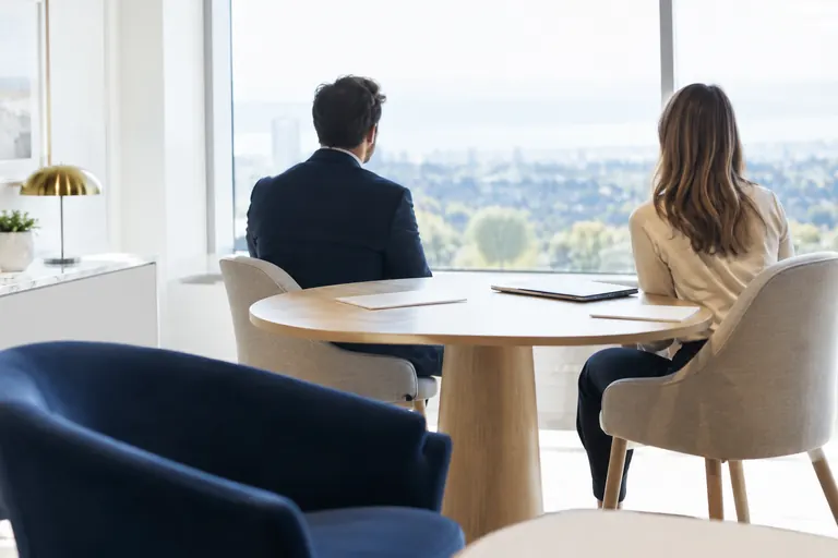 Silhouettes floues de dos lors d’un rendez-vous professionnel dans un bureau lumineux